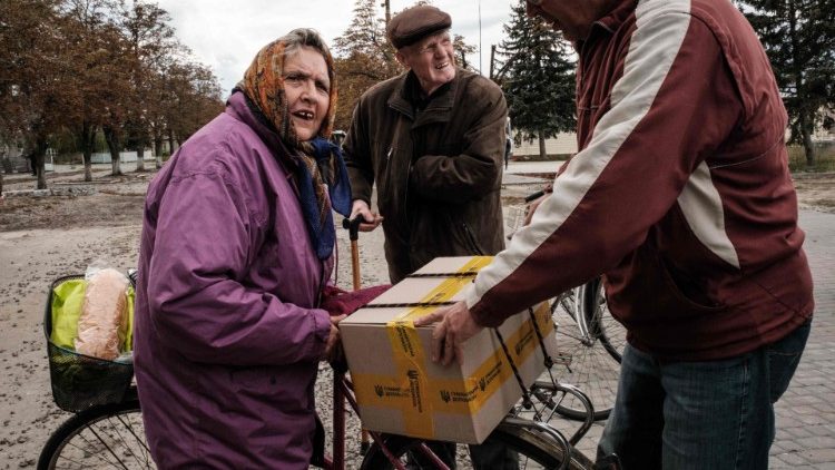 A Ukrainian couple receive food aid in the town of Lyman in Donetsk region amid the Russian invasion