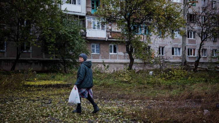 A local resident walks past a damaged residential building after shelling on the town of Bakhmut in Donetsk region, Ukraine