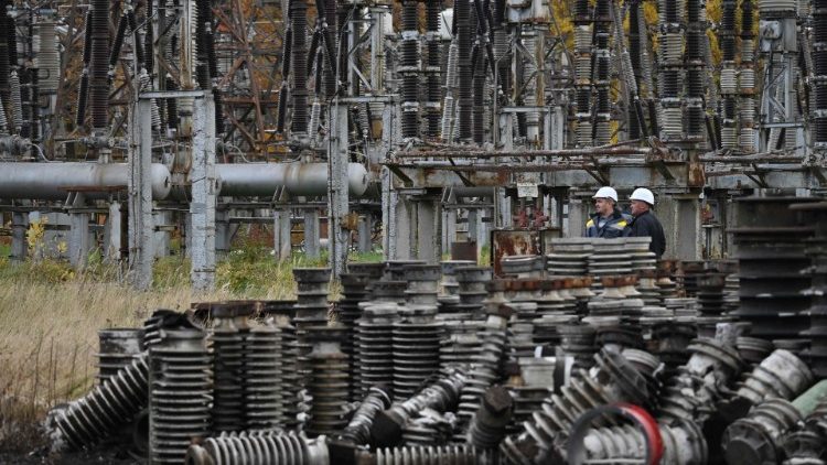 Workers examine damage after a missile strike on a power plant in Ukraine