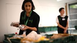 A member od f staff sorts through items in a food-bank  in London