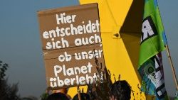 Demonstranten halten ein Plakat an einer Demonstration vor dem Braunkohletagebau Garzweiler bei Lützerath in Westdeutschland