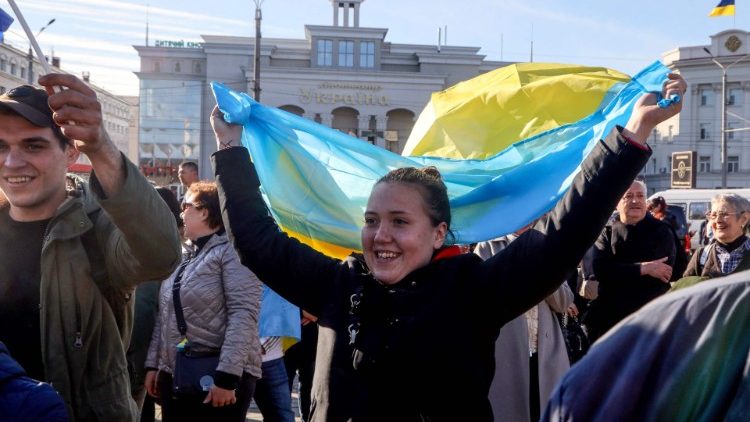 A Ukrainian women waves a flag in the centre of the recently recaptured city of Kherson