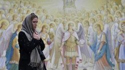 Ucraniana diante de pintura em muro do Mosteiro São Miguel, centro de Kiev.