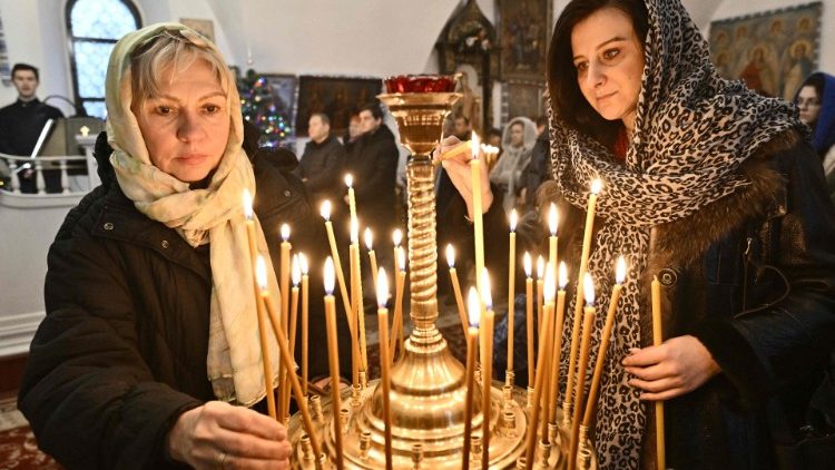 Women light candles at an Orthodox church in Kyiv