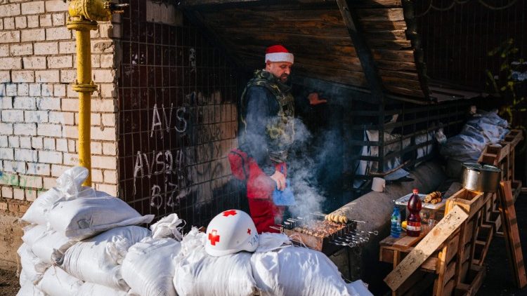Członek Ukraińskiego Czerwonego Krzyża organizujący grilla w Chersoniu, 1 stycznia 2023