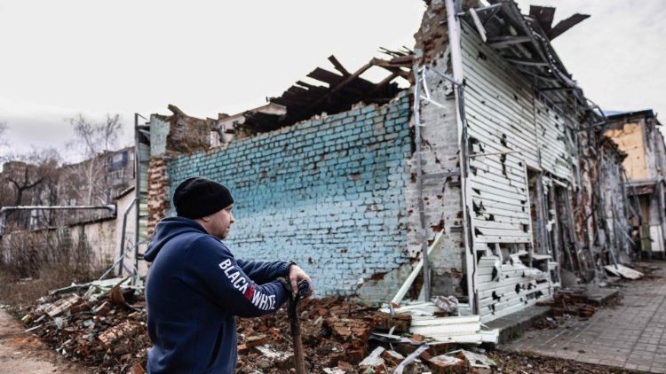 Um morador local remove os escombros perto de sua casa danificada na cidade de Izium, leste da Ucrânia, em 2 de janeiro de 2023. (Foto de Sameer Al-DOUMY / AFP)