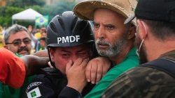 Anhänger des abgewählten brasilianischen Präsidenten Jair Bolsonaro unterstützen einen Offizier der Militärpolizei bei Zusammenstößen nach einem Einmarsch in den Präsidentenpalast Planalto in Brasilia am 8. Januar 2023.