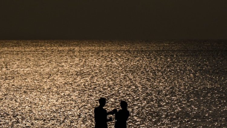 Ein Paar hält Händchen am Meer