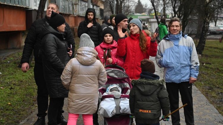 Espectadores falam perto do local onde um helicóptero caiu perto de um jardim de infância em Brovary, nos arredores da capital Kyiv, matando dezesseis pessoas, incluindo duas crianças e o ministro do Interior ucraniano, em 18 de janeiro de 2023, em meio à invasão russa da Ucrânia. (Foto de Sergei Supinsky / AFP)