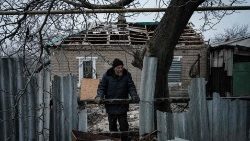 Часів. Украіна. 65-гадовы Аляксандр Савун прыбірае разбітыя сцены пасля трапленьня ракеты ў дом