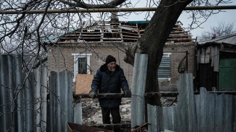 Часів. Украіна. 65-гадовы Аляксандр Савун прыбірае разбітыя сцены пасля трапленьня ракеты ў дом