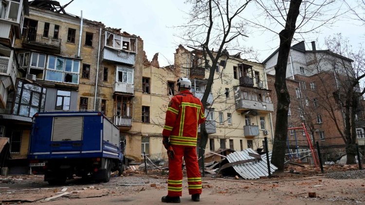 Um socorrista do lado de fora de um prédio residencial parcialmente destruído após um ataque de míssil em Kharkiv em 30 de janeiro de 2023, em meio à invasão russa da Ucrânia. (Foto de SERGEY BOBOK / AFP)
