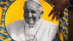 Eine Südsudanesin zeigt einen Stoff mit dem Abbild von Papst Franziskus