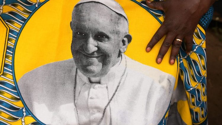 Eine Südsudanesin zeigt einen Stoff mit dem Abbild von Papst Franziskus