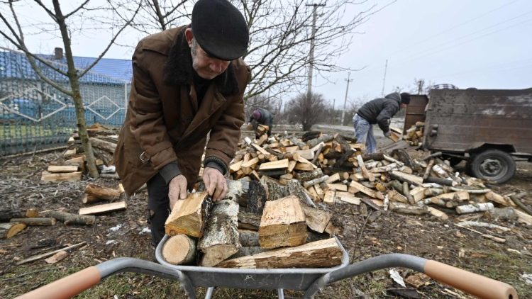Moradores locais coletam lenha doada por um fundo de caridade em Stanislav, região de Kherson, em 31 de janeiro de 2023, em meio à invasão russa da Ucrânia. (Foto de Genya SAVILOV / AFP)