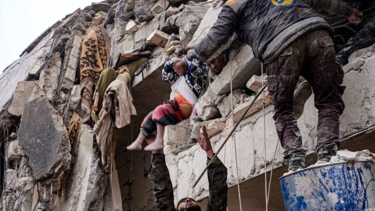 Moradores resgatam uma criança dos escombros de um prédio que desabou após um terremoto na cidade de Jandaris, no interior da cidade de Afrin, no noroeste da Síria, na parte controlada pelos rebeldes da província de Aleppo. (Foto de Rami al SAYED/AFP)