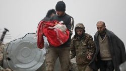 Syřan nese tělo kojence, který zahynul při zemětřesení ve městě Jandaris na severozápadě Sýrie 