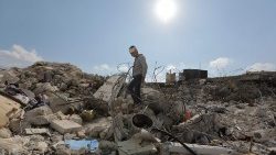 A Syrian boy walks amid the rubble of his family home in Jindayris