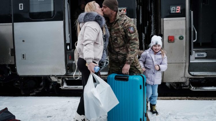 Mykhaylo, 43, um militar ucraniano, baseado em Konstantinovka, beija sua esposa Yulia perto de sua filha Yeva, enquanto recebe sua família após uma separação de mais de três meses, na estação de trem em Kramatorsk em 12 de fevereiro de 2023, em meio a a invasão russa da Ucrânia. (Foto de YASUYOSHI CHIBA/AFP)
