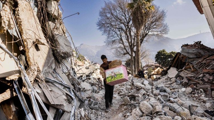 Un uomo cammina tra le macerie del terremoto in Siria