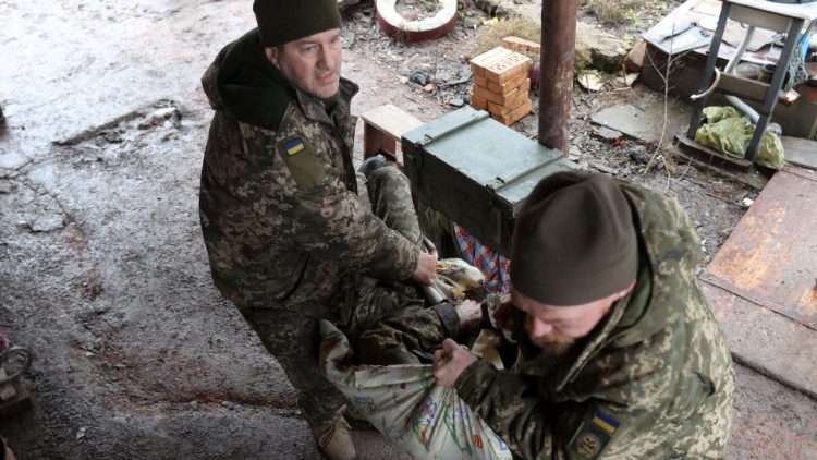 Ukraińscy żołnierze niosący rannego kolegę do punktu medycznego, obwód doniecki, 28 lutego 2023