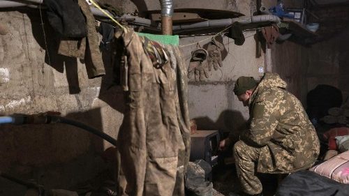 A Ukrainian soldier sits in a dugout in Bakhmut