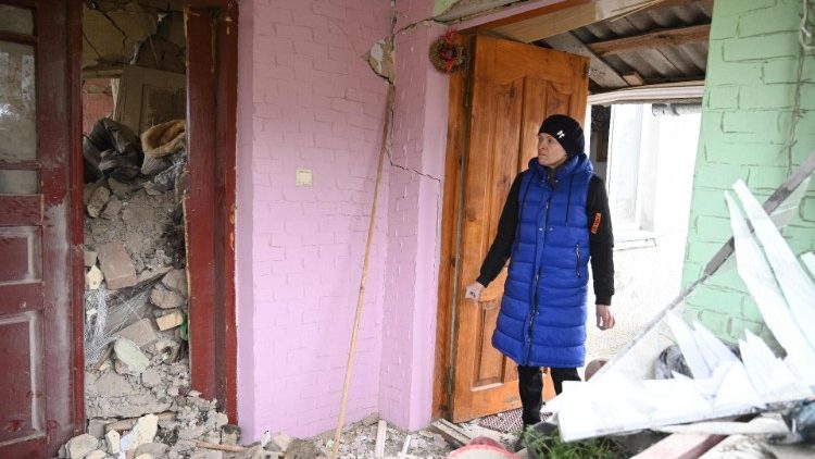 Uma mulher vasculha os escombros da casa destruída de seus parentes após um ataque russo na vila de Velyka Vilshanytsia, a cerca de 50 km de Lviv, em 9 de março de 2023.  (Photo by YURIY DYACHYSHYN / AFP)