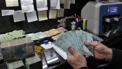 A man handles Lebanese pound bills at a currency exchange office in Beirut on March 14, 2023.
