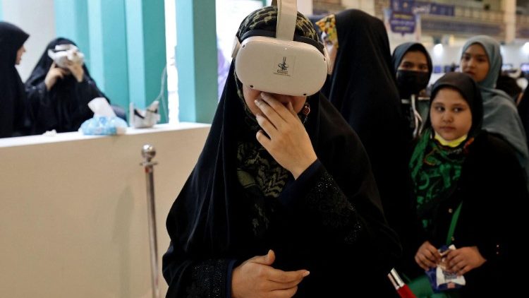 EIne verschleierte Iranierin trägt eine VR-Brille auf der International Holy Koran Fair in Teheran