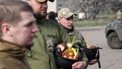 Ukraińscy żołnierze z pokarmami do poświęcenia w hełmach w dniu obchodzenia przez nich Wielkanocy, Kramatorsk, obwód doniecki, 16 kwietnia 2023