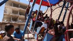 Kinder spielen inmitten von Gebäuden, die bei dem Erdbeben, das die Türkei und Syrien im Februar erschütterte, beschädigt wurden