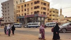 Women walk along a street in Khartoum