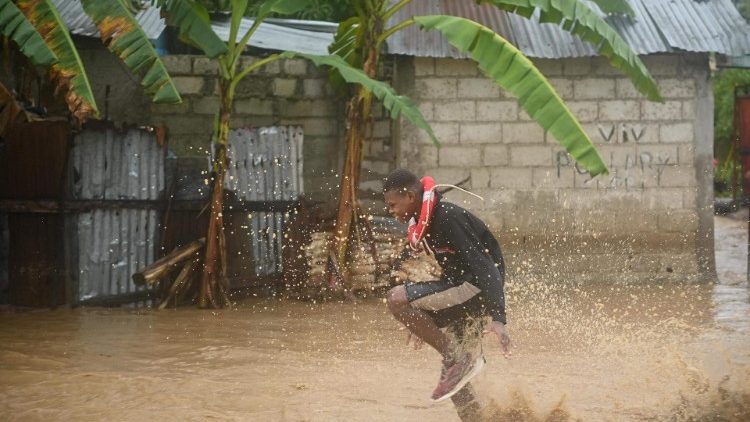 Residente atravessa estradas inundadas nos bairros de Petit-Gove, Haiti, em 3 de junho de 2023, durante fortes chuvas no Haiti. (Foto de Richard PIERRIN/AFP)