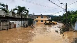 Varias personas vadean una calle inundada en Esmeraldas, Ecuador, el 4 de junio de 2023. Más de 500 personas fueron evacuadas el domingo.