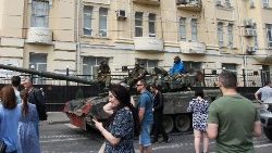 Members of the Wagner group sit atop a tank in a street in Rostov-on-Don
