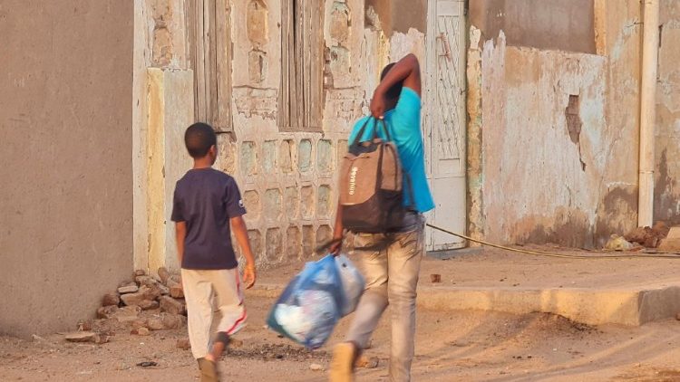 Joven sudanés carga con sus pertenencias mientras huye de los combates.