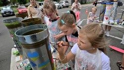 Ukrainische Kinder bemalen gefallene Raketenhülle für das Gedenkmuseum in Butscha