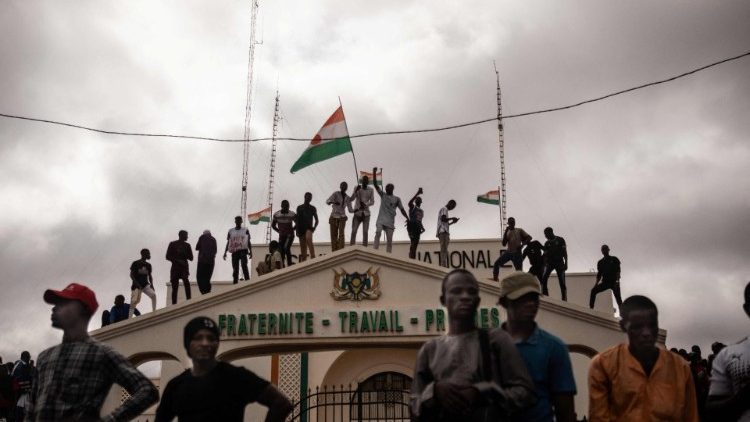 Protesters hold a Niger flag during a demonstration on independence day in Niamey, 3 August.