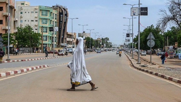 A woman walks across a quiet road in Niamey, Niger on 8 August.
