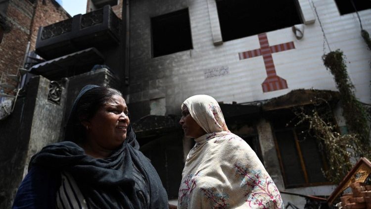 Cristãos paquistaneses diante da Igreja queimada de São João, em Jaranwala. (Photo by Aaamir Qureshi/AFP)