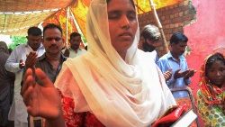 Betende Frau beim Sonntags-Gottesdienst in Jaranwala, neben dem ausgebrannten Gebäude der Heilsarmee