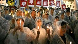 जापान के फुकुशिमा में रेडियोधर्मी जल को समुद्र में छोड़ने के निश्चय का विरोध करते दक्षिणी के लोग मोमबत्ती जुलूस के साथ