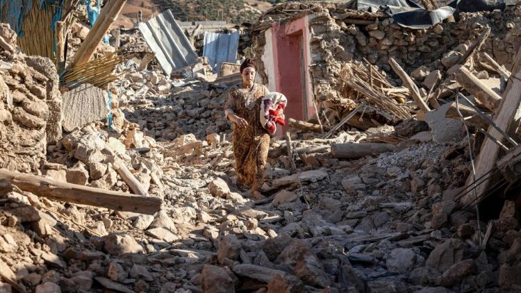 地震で倒壊した家々の間を歩く女性　2023年9月9日　モロッコ・マラケシュ西南の山間部の村で