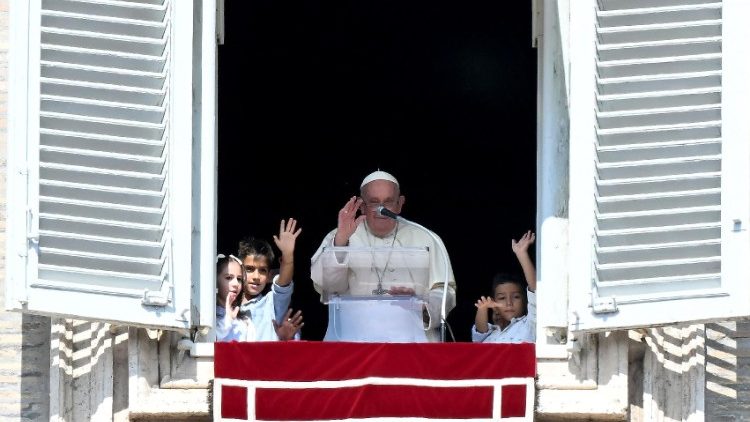 El Papa se asoma desde el balcón pontificio junto a cinco niños.