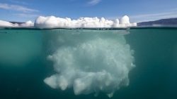Esta fotografía submarina tomada el 16 de agosto de 2023 muestra un iceberg derritiéndose debido a temperaturas inusualmente altas, en Groenlandia