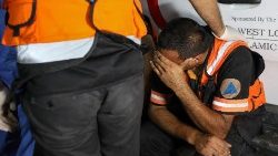 Egészségügyi dolgozó sír a gázai kórház előtt