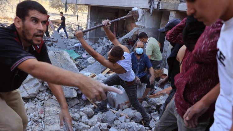 Palestinians dig in the rubble of a destroyed building following an Israeli airstrike in Rafah, southern Gaza