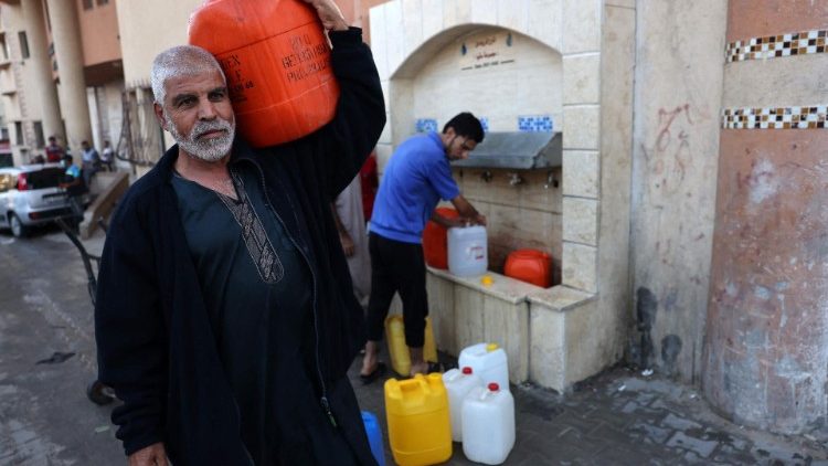  People fetch water from a fountain in Rafah in the southern Gaza Strip on 20 October 2023.