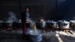 Palestinians prepare meals for the UN shelter to be distributed to the displaced in Rafah, on the southern Gaza Strip 