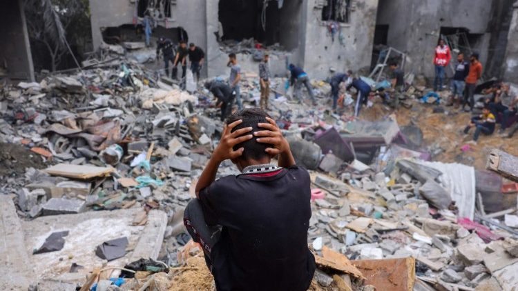 Uma criança palestina em meio aos escombros de um prédio destruído após ataques em Rafah, no sul da Faixa de Gaza